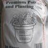 Close-up of a bag of premium potting and planting mix, with an illustration of a pot with blooming flowers in it.