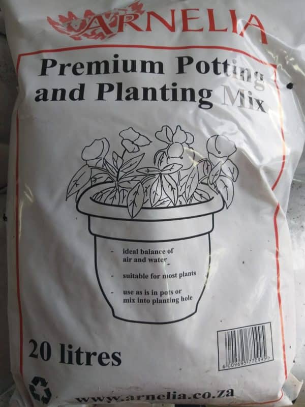 Close-up of a bag of premium potting and planting mix, with an illustration of a pot with blooming flowers in it.