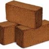 Three brown brick-sized blocks of coco coir.