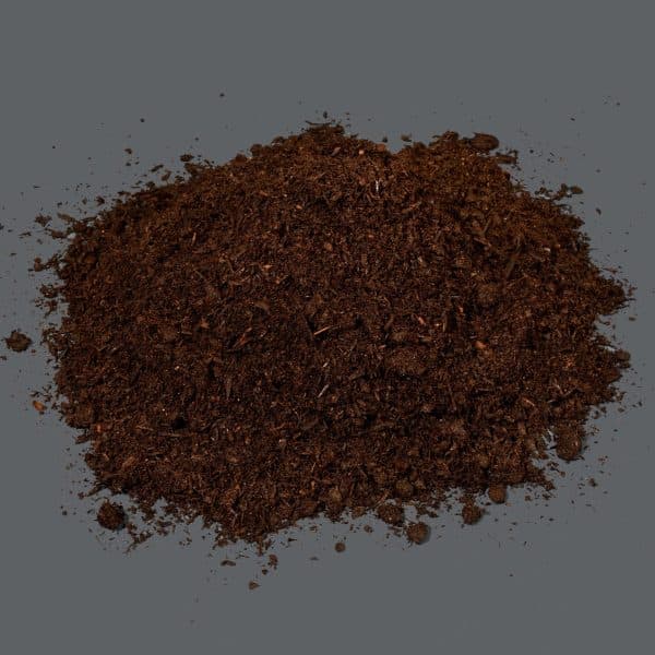 A heap of dark brown compost on a black background.