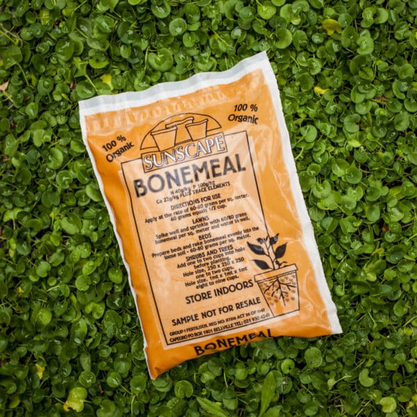 A bag of Sunscape bonemeal fertiliser placed on a bed of lush green clover leaves.