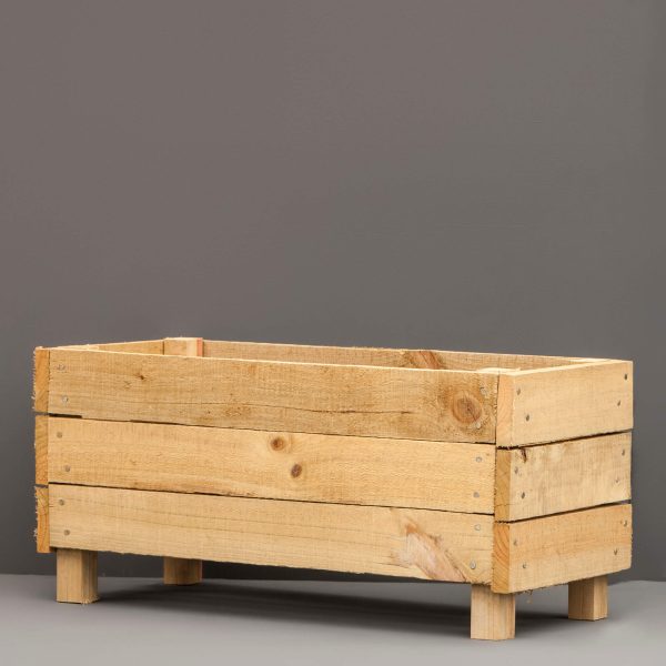 A rectangular wooden planter box against a grey background.