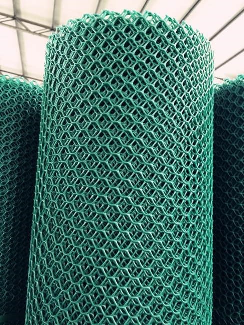 Close-up of a roll of bright green plastic mesh material with a diamond-shaped pattern.