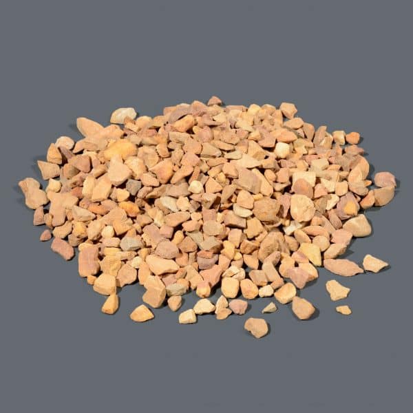 A small pile of drainage chips resembling small light brown stones.
