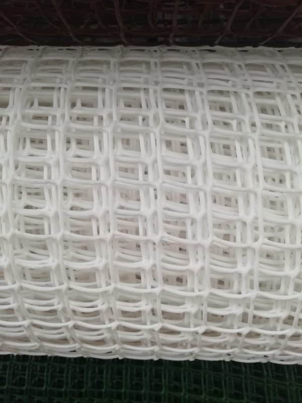 A close-up view of thin, white plastic mesh with a grid pattern.