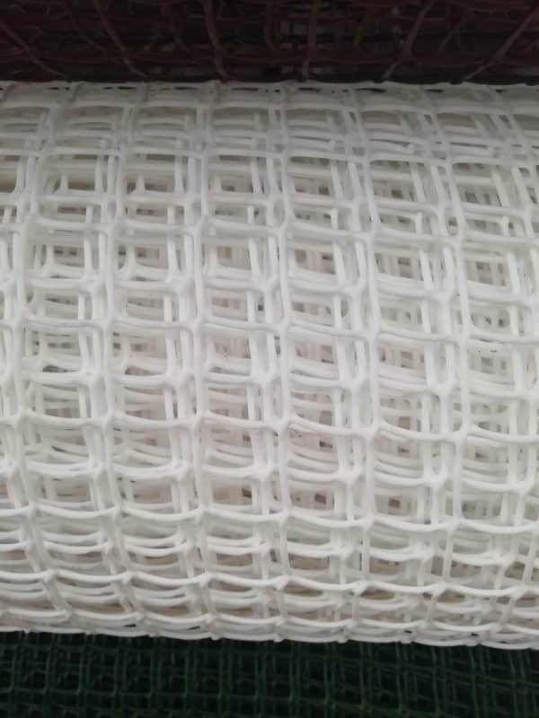 A close-up view of thin, white plastic mesh with a grid pattern.