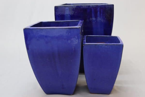 Three dark blue glazed square pots of various sizes.