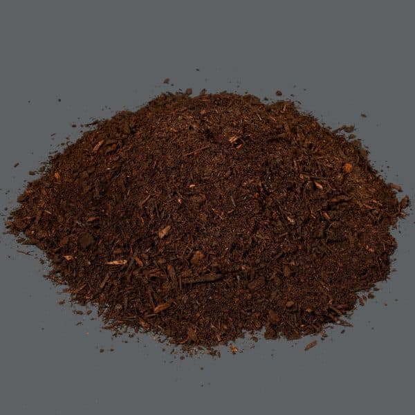 A small pile of dark brown kraal manure on a dark background.
