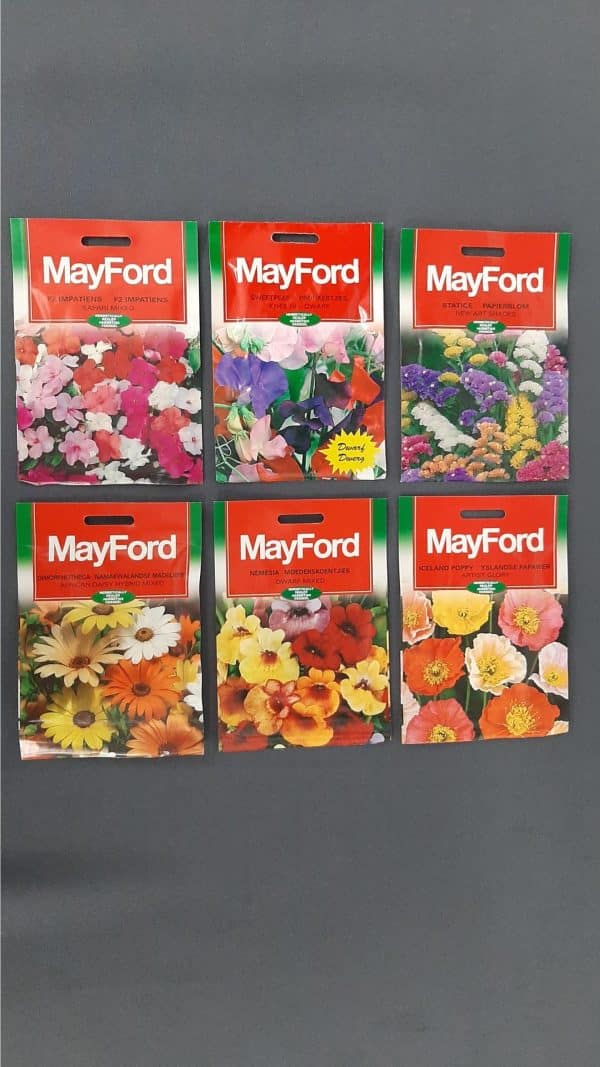 Six pack of various Mayford flower seeds against a black background.