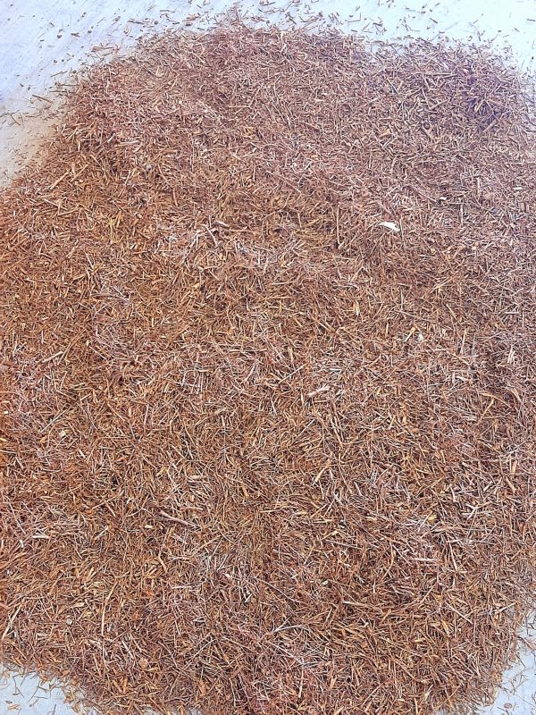 Close-up of a pile of light brown rooibos mulch.