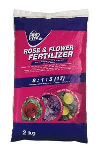 A pink and dark blue bag of rose and flower fertiliser weighing 2kg.