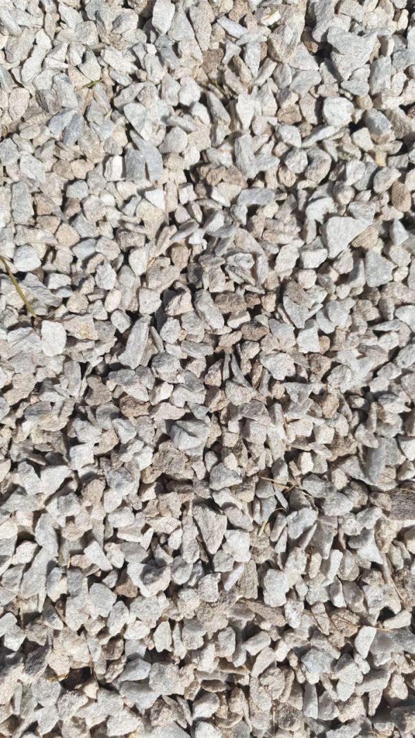 Dense pile of crushed limestone aggregate with rough, angular surfaces in light grey and tan hues.