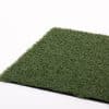 A square of green artificial grass on a white surface.