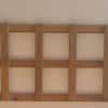 Eight rectangular wooden frames mounted horizontally in a row on a white wall.