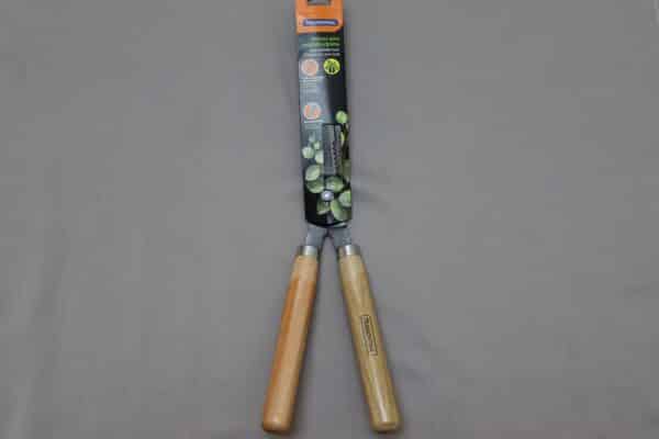 Large hedge shears with wooden handles on a grey background.