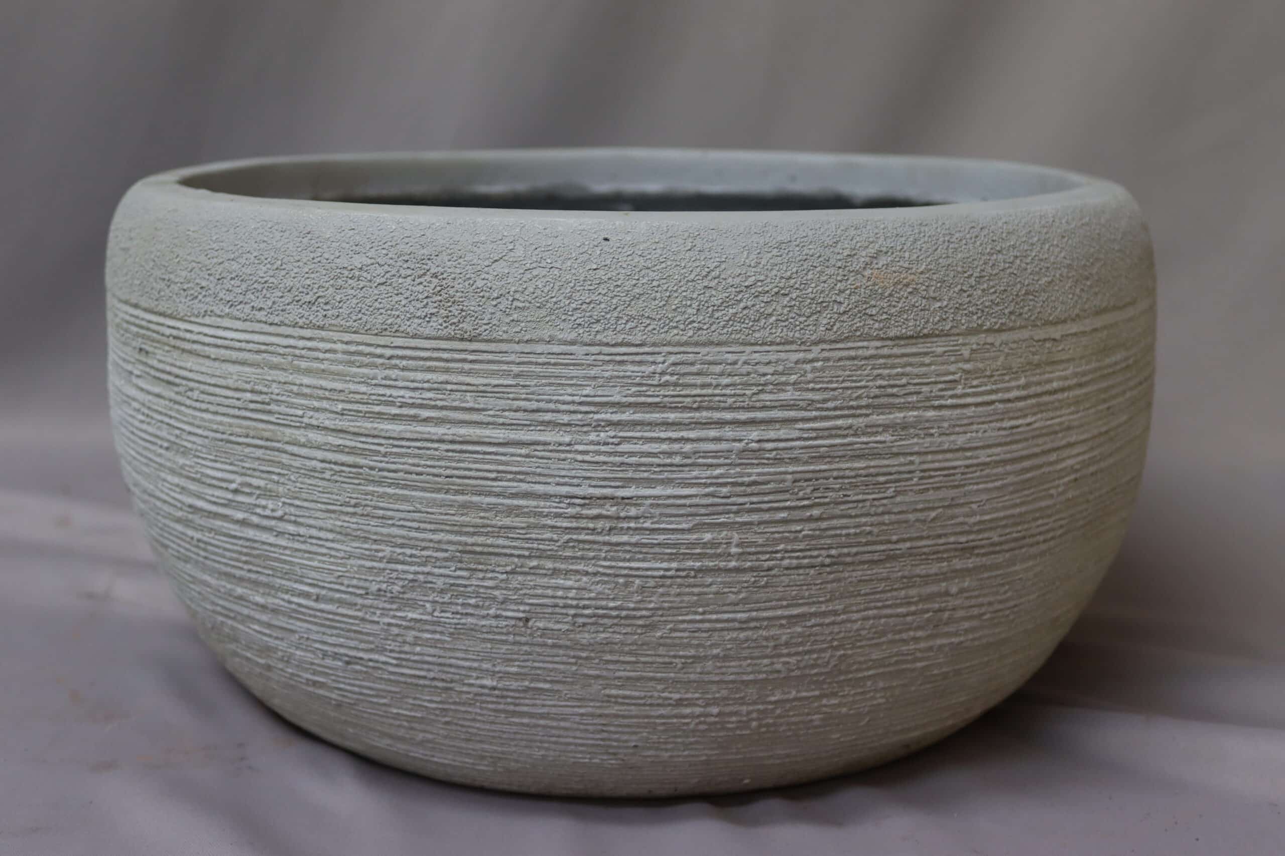 Round decorative stone plant bowl in light grey.