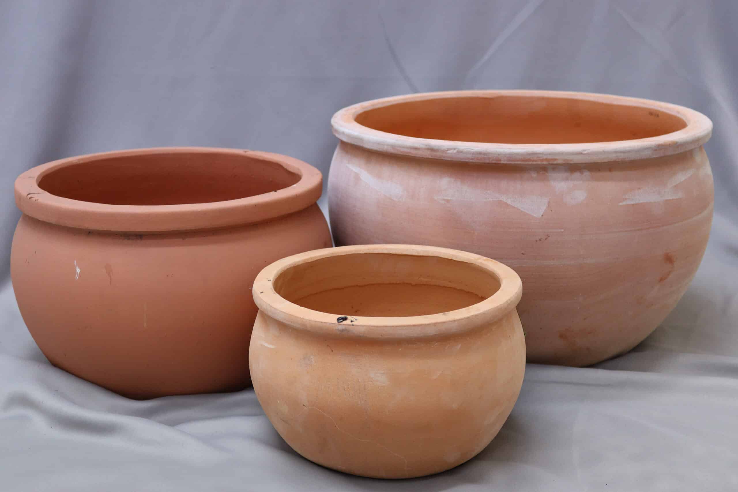 Three terracotta plant pots of different sizes, all with flat rims.