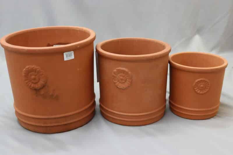 Large, small and medium embossed ceramic cylinder pots in terracotta colour.embossment.