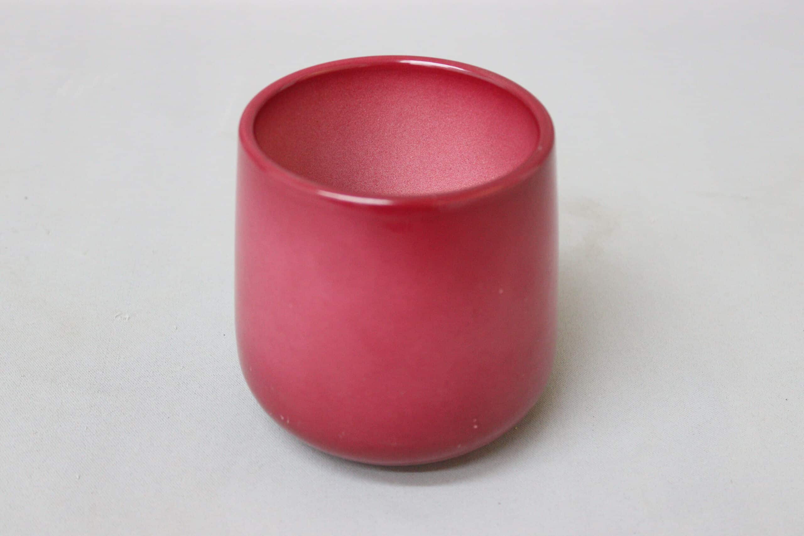 Cerise-coloured urn-shaped ceramic pot cover.