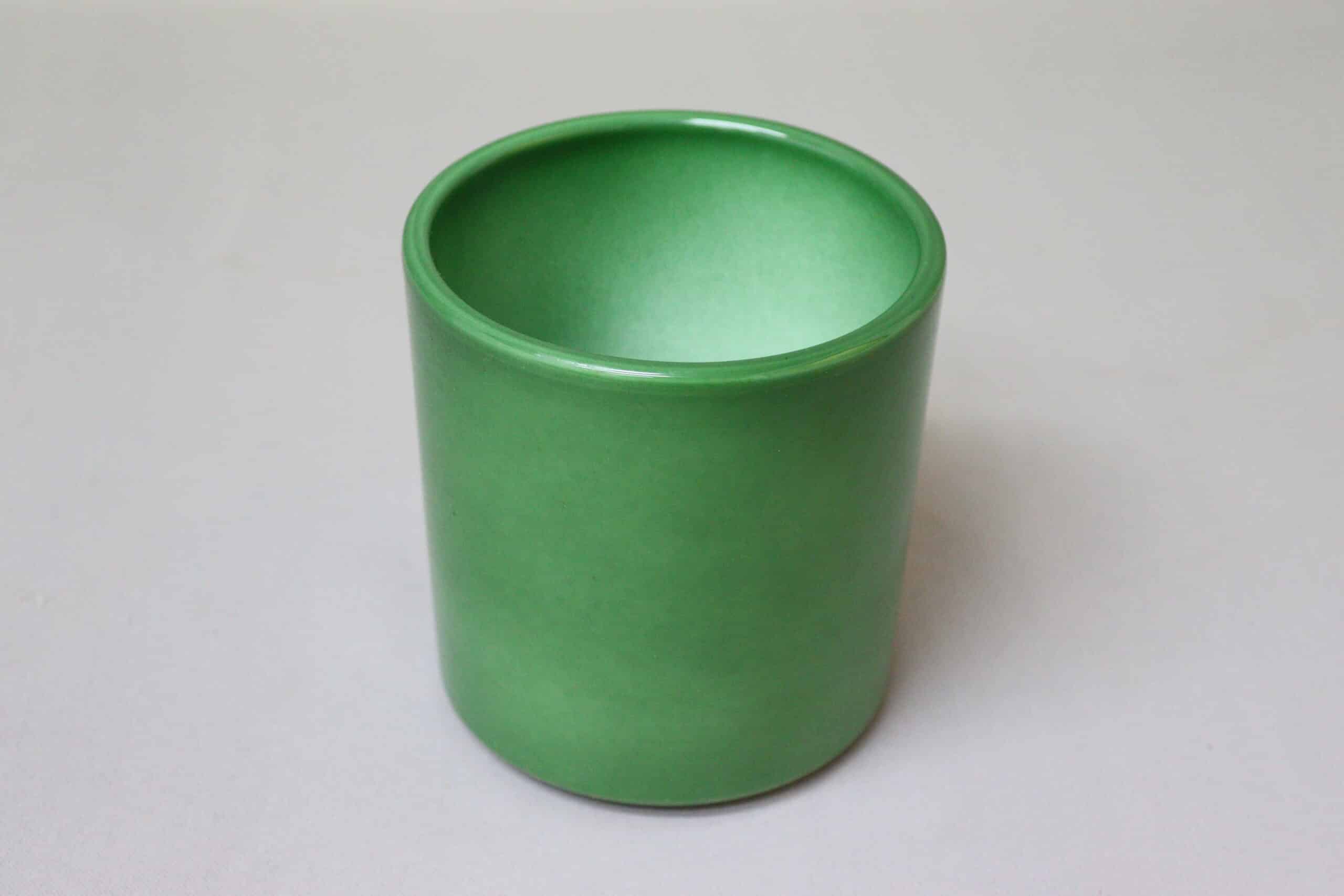 Bright green pot cover with smooth sides for potted plants.