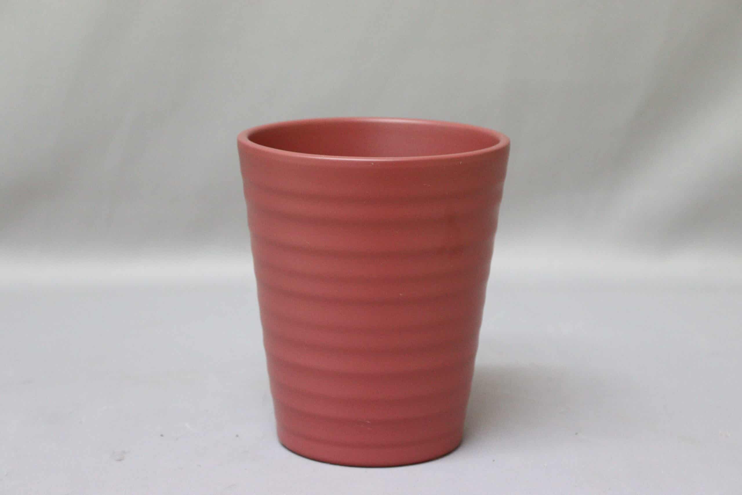 Tall pink maroon pot cover with line detail for potted plants.