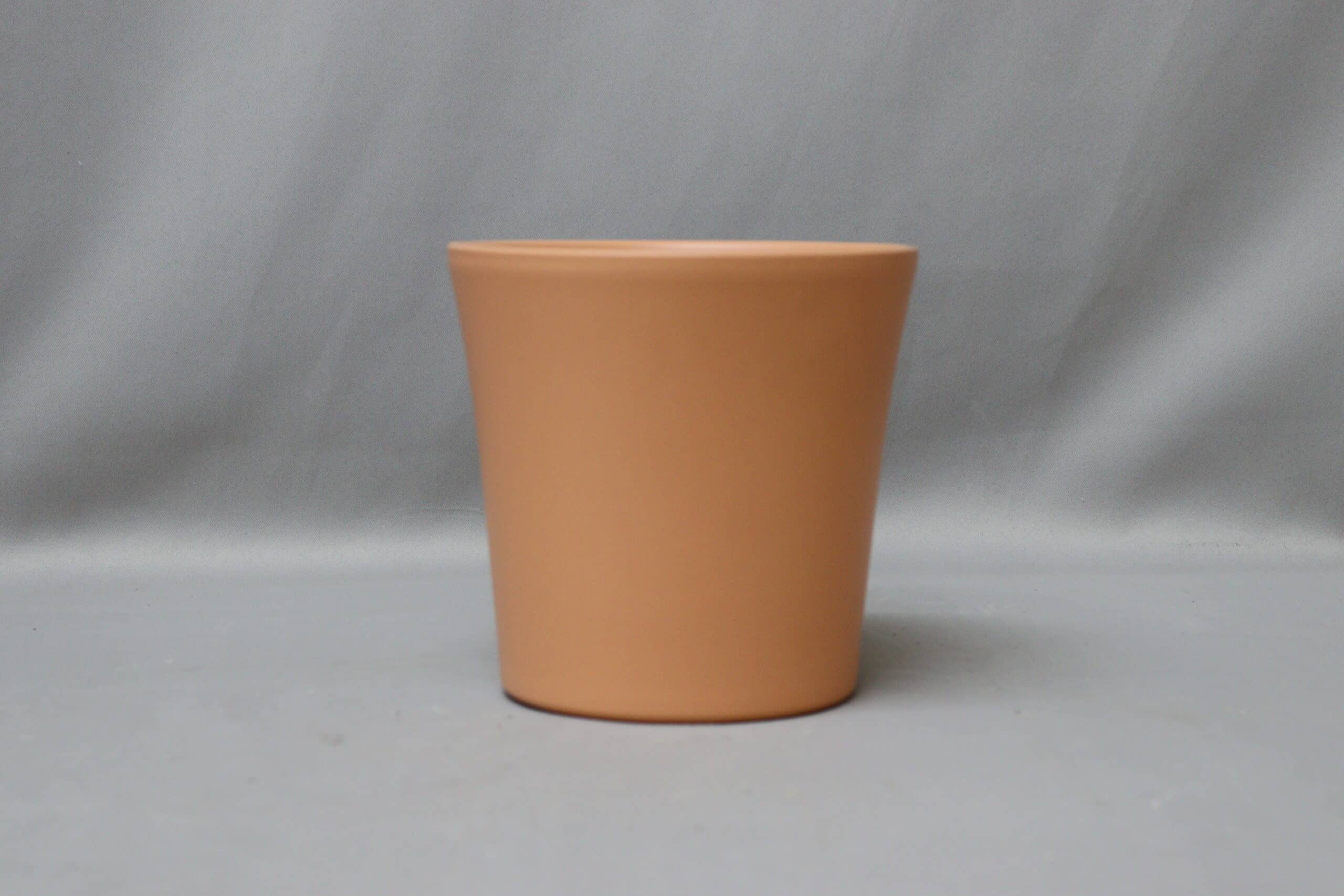 Terracotta-coloured pot cover for potted plants.