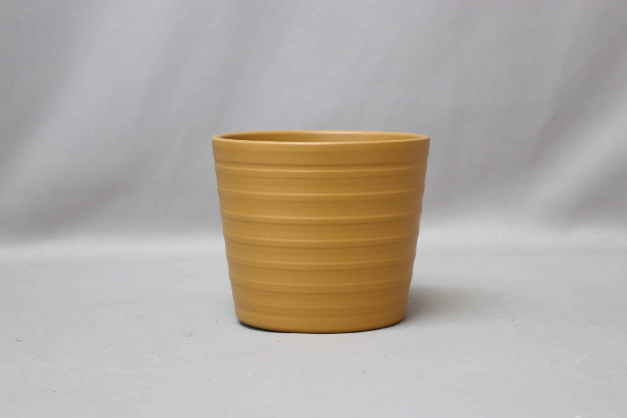 Caramel-coloured, ribbed pot cover for potted plants.