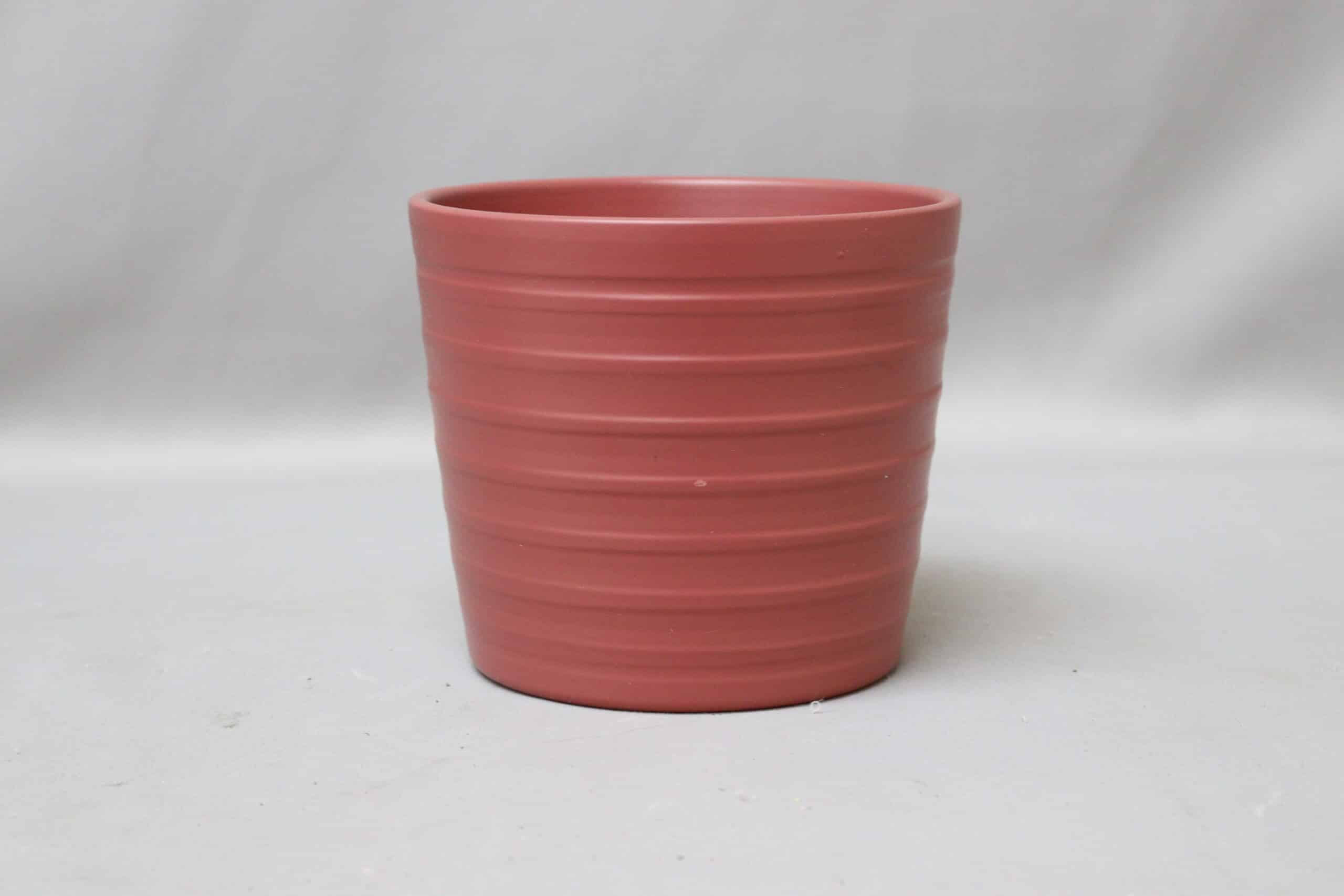 Cerise-pink, ribbed pot cover for potted plants.